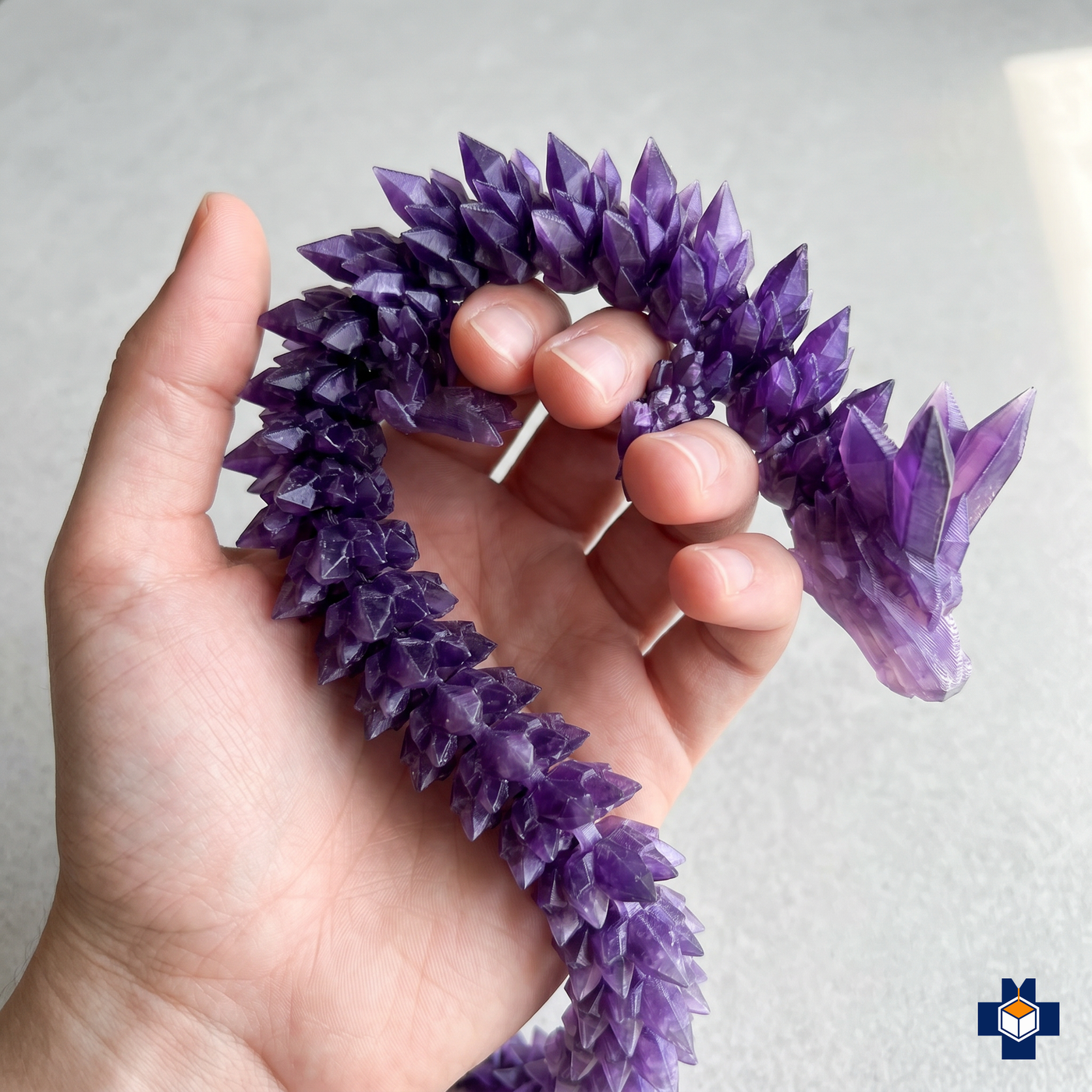 SPARK crystal dragon held in hand, showing fidget articulation